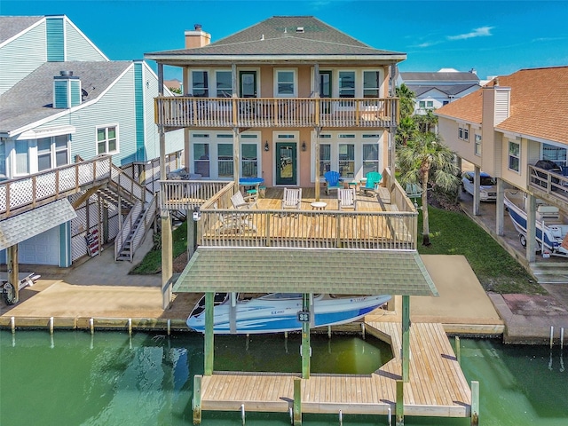 247 Isles End Rd, Tiki Island, TX 77554 - back of property with a water view, stucco siding, a balcony, a chimney, and roof with shingles