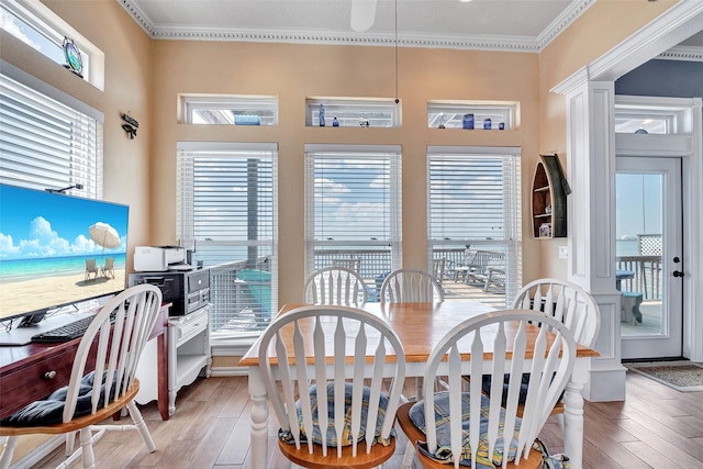 247 Isles End Rd, Tiki Island, TX 77554 - dining room featuring light wood finished floors, plenty of natural light, crown molding, and ornate columns