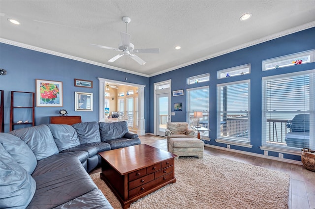 247 Isles End Rd, Tiki Island, TX 77554 - living room featuring ceiling fan, healthy amount of natural light, recessed lighting, a textured ceiling, and crown molding