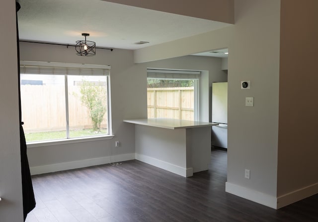 1204 Osborne Dr, Friendswood, TX 77546 - empty room with dark wood-type flooring, baseboards, and a chandelier