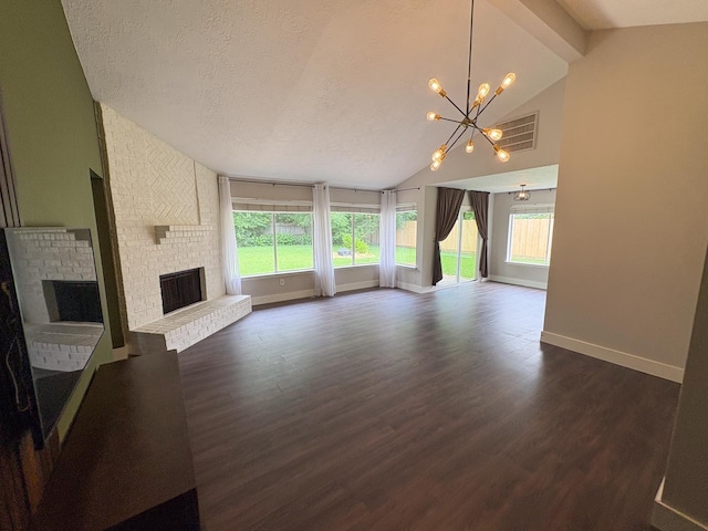 1204 Osborne Dr, Friendswood, TX 77546 - unfurnished living room featuring a brick fireplace, a chandelier, plenty of natural light, dark wood finished floors, and a textured ceiling
