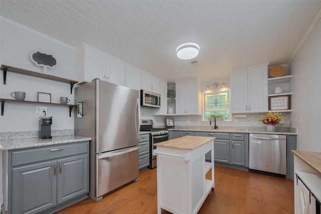 810 Stubbs St, La Marque, TX 77568 - kitchen with open shelves, stainless steel appliances, gray cabinetry, wood counters, and a sink