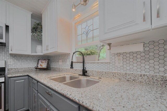 810 Stubbs St, La Marque, TX 77568 - kitchen featuring a sink, gray cabinets, white cabinets, and backsplash
