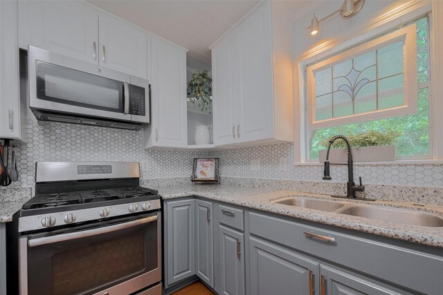 810 Stubbs St, La Marque, TX 77568 - kitchen with stainless steel appliances, a sink, gray cabinets, decorative backsplash, and white cabinetry
