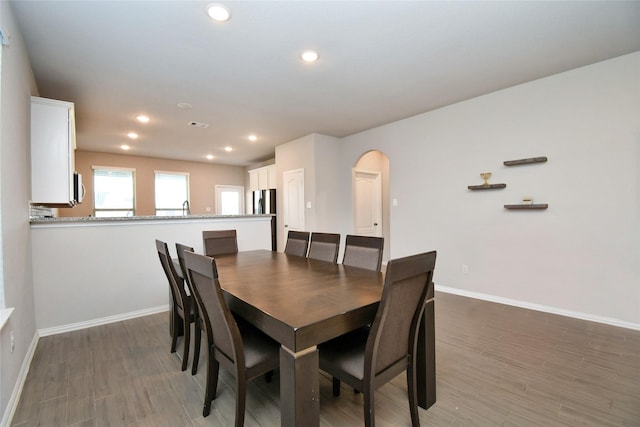 7419 French Quarter Ct, Fulshear, TX 77441 - dining area featuring baseboards, arched walkways, wood finished floors, and recessed lighting
