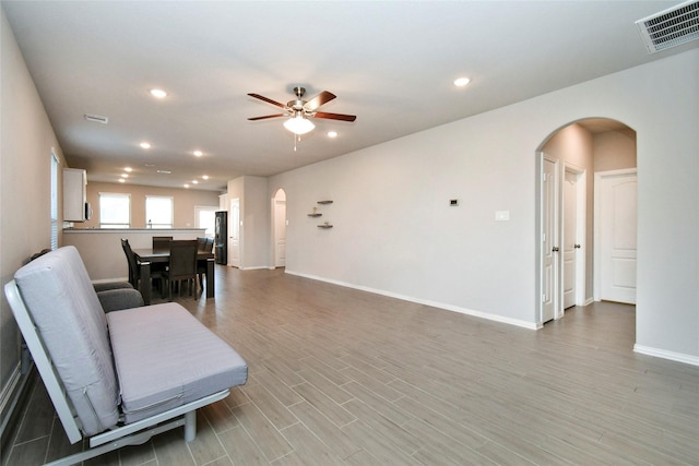 7419 French Quarter Ct, Fulshear, TX 77441 - living room with arched walkways, a ceiling fan, recessed lighting, baseboards, and light wood-type flooring