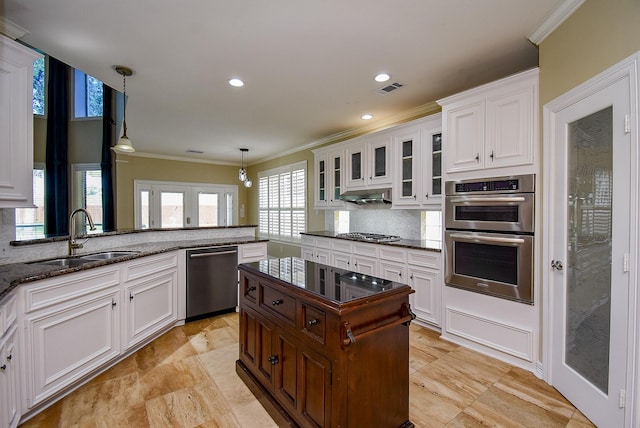 3911 Fielder Cir, Missouri City, TX 77459 - kitchen featuring appliances with stainless steel finishes, a sink, ornamental molding, decorative backsplash, and white cabinetry