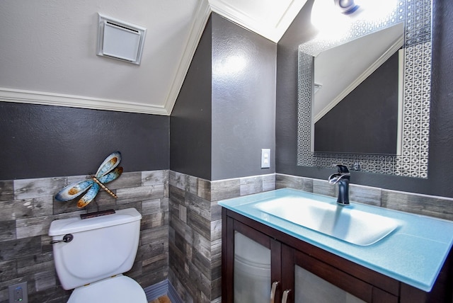 3911 Fielder Cir, Missouri City, TX 77459 - bathroom featuring tile walls, toilet, vanity, a wainscoted wall, and vaulted ceiling