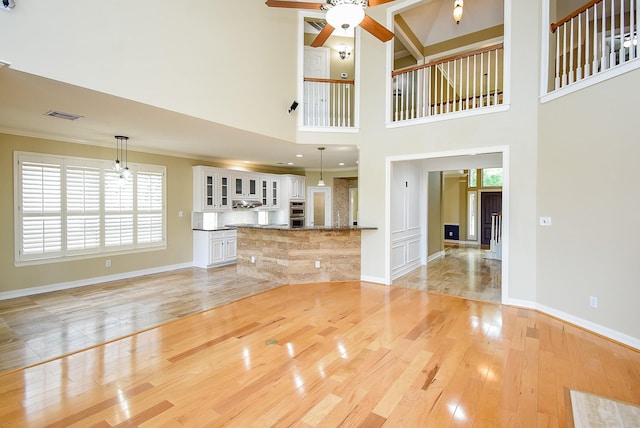 3911 Fielder Cir, Missouri City, TX 77459 - unfurnished living room featuring a ceiling fan, baseboards, light wood finished floors, and ornamental molding