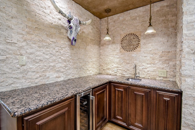 3911 Fielder Cir, Missouri City, TX 77459 - kitchen featuring wine cooler, a sink, dark stone counters, and decorative light fixtures