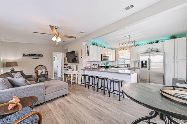 4126 Reeves Dr, Galveston, TX 77554 - living room with light wood finished floors and a ceiling fan