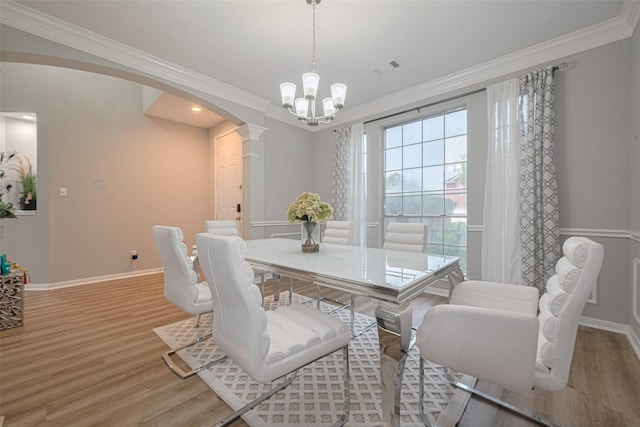6718 Cleft Stone Dr, Houston, TX 77084 - dining space with arched walkways, ornamental molding, light wood-style flooring, baseboards, and decorative columns