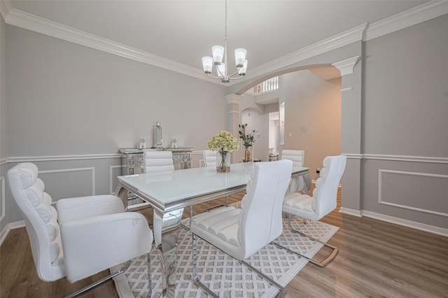 6718 Cleft Stone Dr, Houston, TX 77084 - dining area with arched walkways, ornamental molding, decorative columns, wood finished floors, and a chandelier