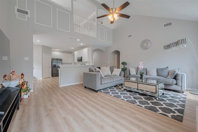 6718 Cleft Stone Dr, Houston, TX 77084 - living room with arched walkways, high vaulted ceiling, light wood-type flooring, ceiling fan, and baseboards