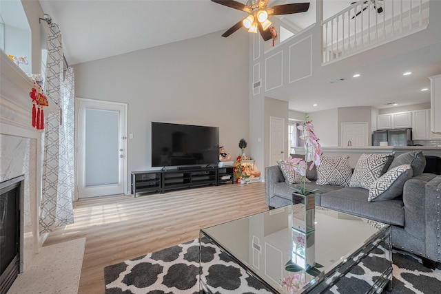 6718 Cleft Stone Dr, Houston, TX 77084 - living room featuring high vaulted ceiling, wood finished floors, a ceiling fan, a high end fireplace, and recessed lighting