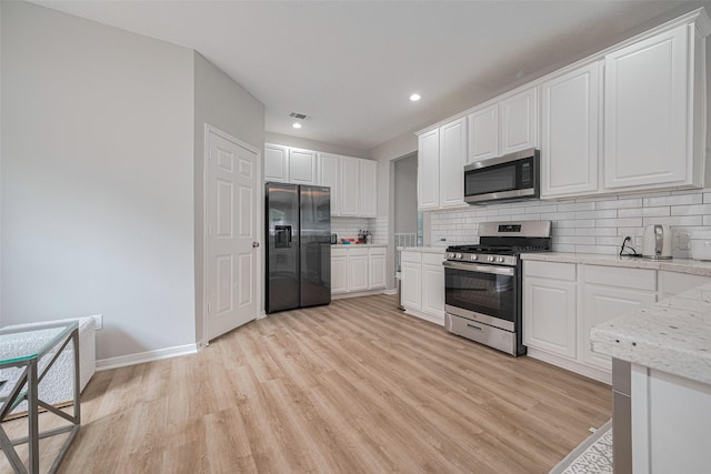 6718 Cleft Stone Dr, Houston, TX 77084 - kitchen featuring stainless steel appliances, light wood-style floors, backsplash, white cabinetry, and recessed lighting