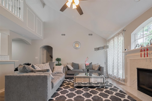 6718 Cleft Stone Dr, Houston, TX 77084 - living room featuring arched walkways, high vaulted ceiling, ceiling fan, a high end fireplace, and wood finished floors