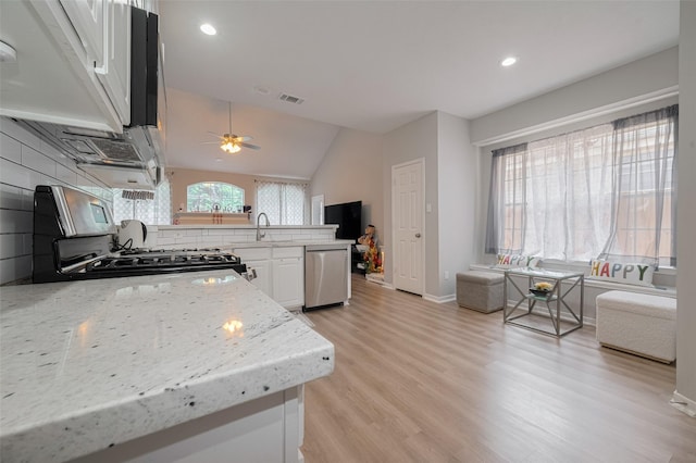 6718 Cleft Stone Dr, Houston, TX 77084 - kitchen featuring stainless steel dishwasher, gas range, a sink, white cabinetry, and light wood-style floors