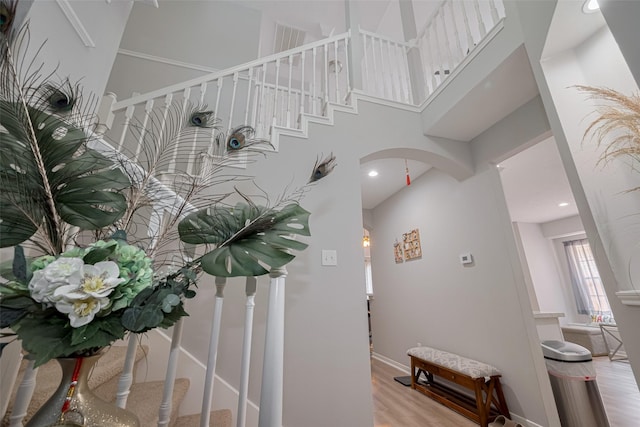 6718 Cleft Stone Dr, Houston, TX 77084 - stairs featuring arched walkways, wood finished floors, a high ceiling, baseboards, and recessed lighting