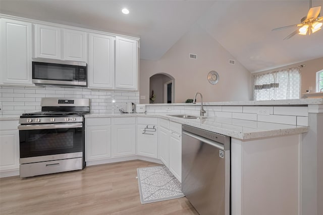 6718 Cleft Stone Dr, Houston, TX 77084 - kitchen with stainless steel appliances, a sink, arched walkways, a peninsula, and decorative backsplash