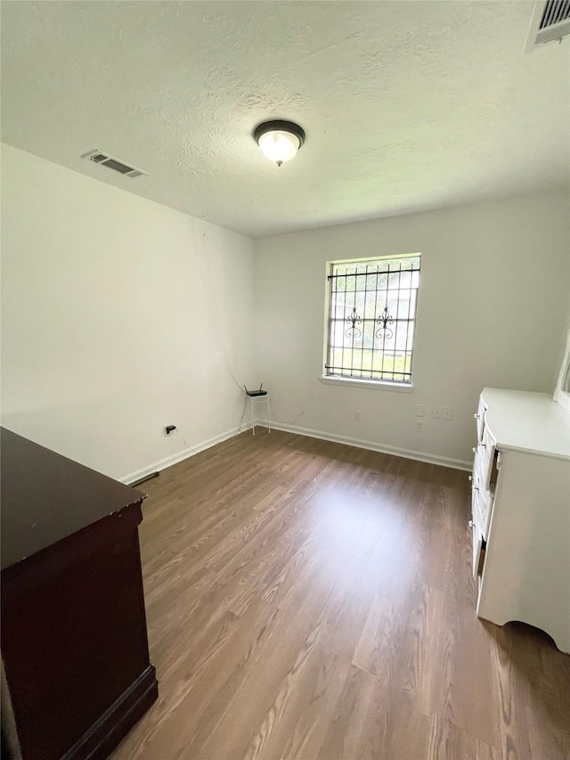 4118 Ebbtide Dr, Houston, TX 77045 - laundry area with wood finished floors, a textured ceiling, and baseboards