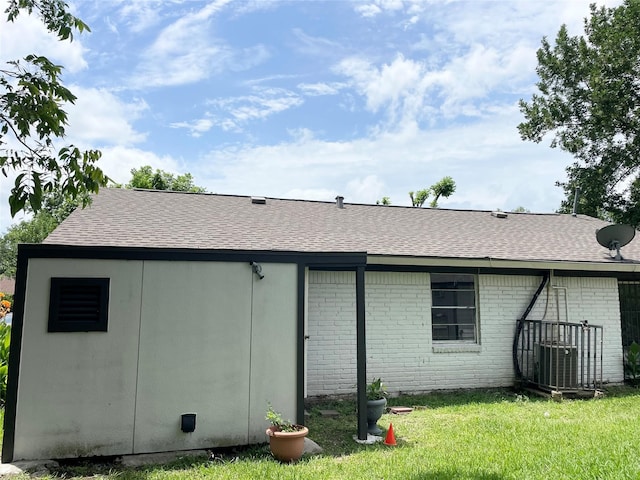 4118 Ebbtide Dr, Houston, TX 77045 - back of house with a shingled roof, a yard, brick siding, and cooling unit