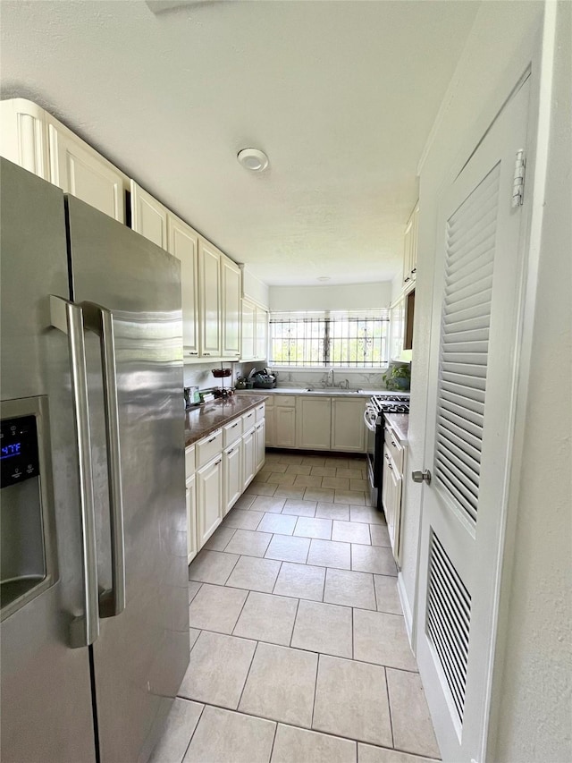 4118 Ebbtide Dr, Houston, TX 77045 - kitchen featuring stainless steel appliances, light tile patterned floors, and a sink