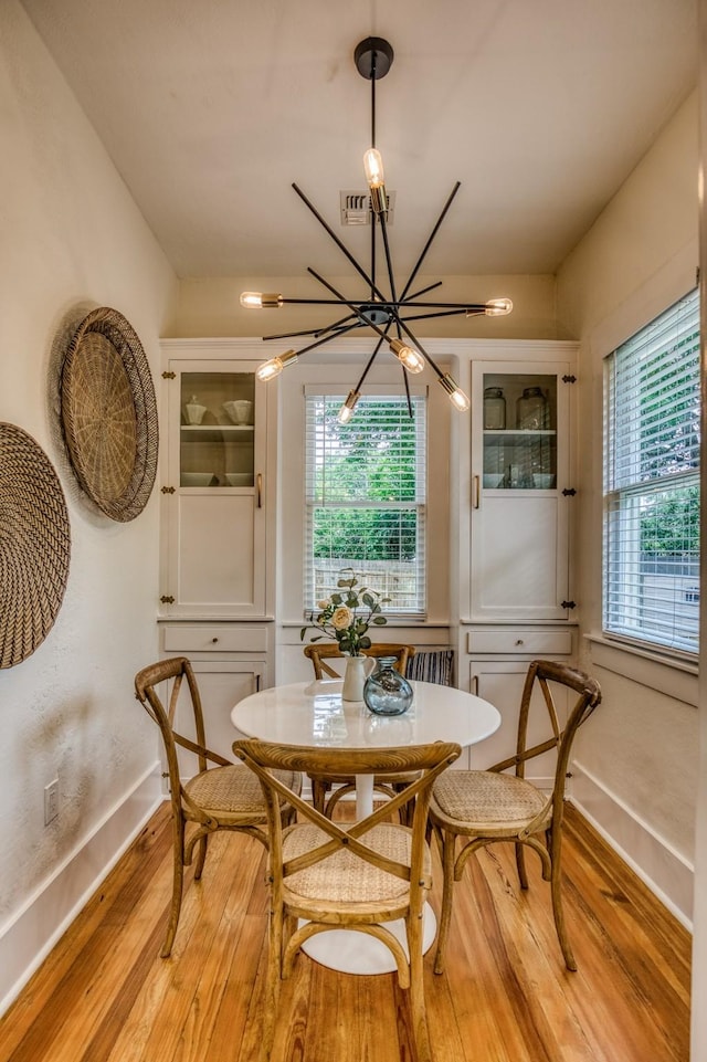 1708 S Park St, Brenham, TX 77833 - dining space featuring a chandelier, baseboards, and light wood-style flooring