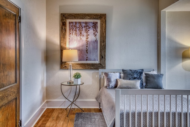 1708 S Park St, Brenham, TX 77833 - bedroom with baseboards, wood finished floors, and a textured wall