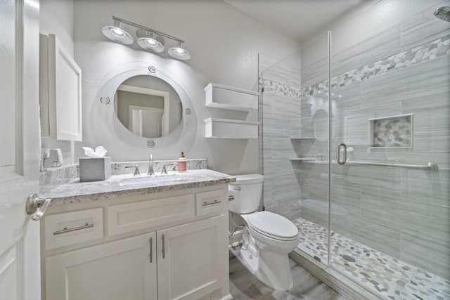 2517 Royal Terns Ct, League City, TX 77573 - bathroom featuring toilet, a stall shower, vanity, a textured wall, and wood finished floors