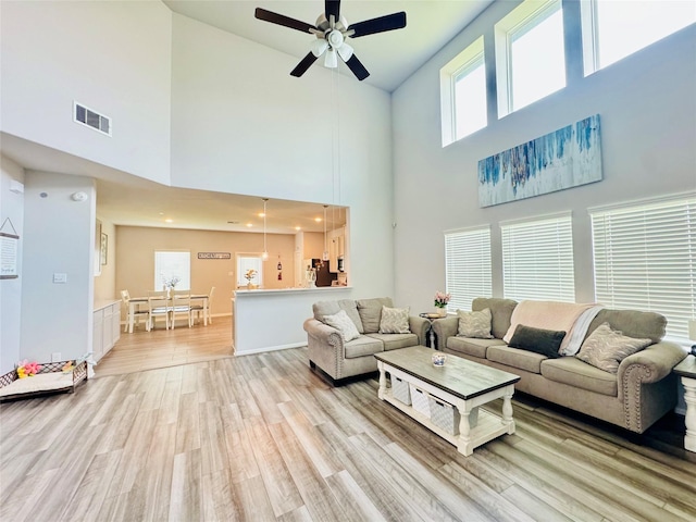 8835 Willet St, Baytown, TX 77521 - living room featuring a ceiling fan, light wood finished floors, and high vaulted ceiling