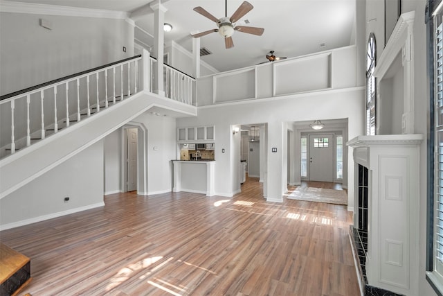 15034 Elstree Dr, Channelview, TX 77530 - unfurnished living room featuring ceiling fan, stairway, baseboards, a towering ceiling, and wood finished floors