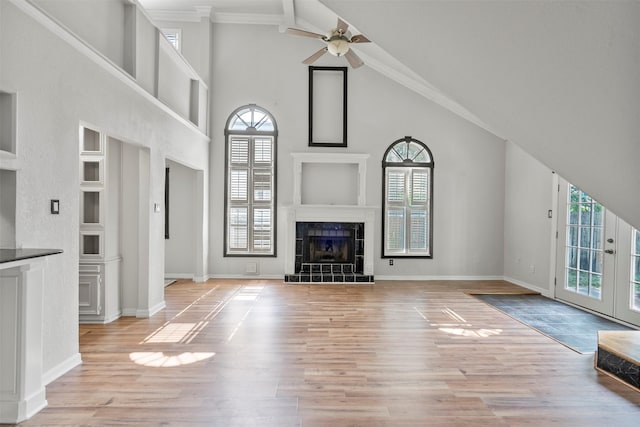 15034 Elstree Dr, Channelview, TX 77530 - unfurnished living room featuring light wood-type flooring, a ceiling fan, high vaulted ceiling, baseboards, and a tiled fireplace