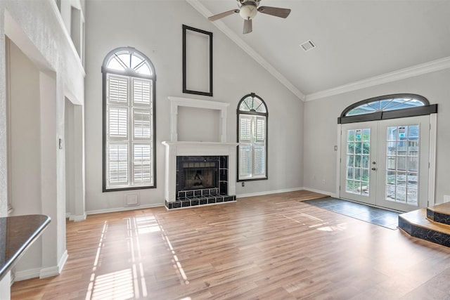 15034 Elstree Dr, Channelview, TX 77530 - unfurnished living room with plenty of natural light, french doors, high vaulted ceiling, light wood finished floors, and a tiled fireplace