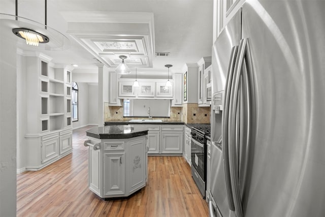 15034 Elstree Dr, Channelview, TX 77530 - kitchen featuring stainless steel appliances, a center island, light wood-type flooring, decorative backsplash, and white cabinetry