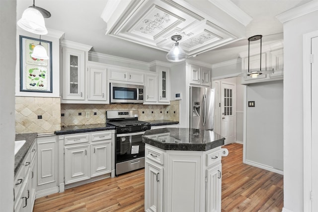 15034 Elstree Dr, Channelview, TX 77530 - kitchen featuring stainless steel appliances, dark countertops, white cabinets, light wood finished floors, and ornamental molding