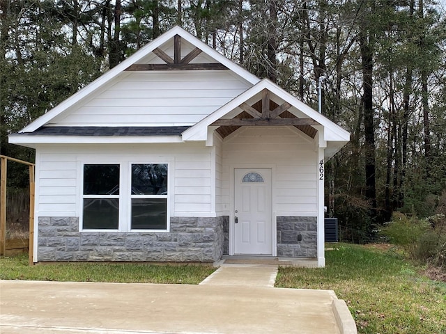 462 Westchase, Montgomery, TX 77316 - view of front facade featuring stone siding, an outbuilding, and a shingled roof