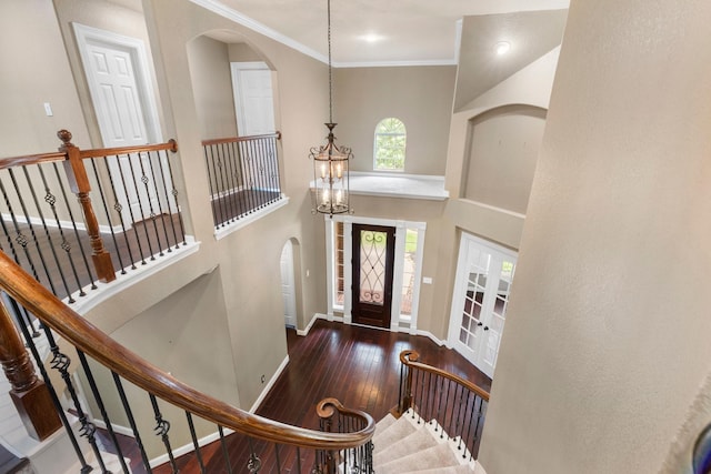 95 W Hullwood Cir, The Woodlands, TX 77389 - entryway featuring arched walkways, baseboards, hardwood / wood-style flooring, crown molding, and a chandelier