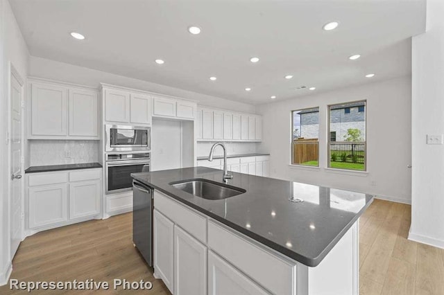 27007 Golden Isle Ln, Katy, TX 77493 - kitchen featuring appliances with stainless steel finishes, a sink, recessed lighting, white cabinets, and a kitchen island with sink