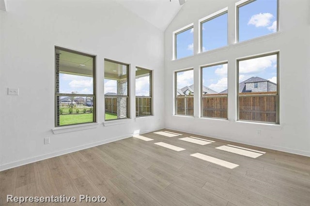 27007 Golden Isle Ln, Katy, TX 77493 - unfurnished room featuring wood finished floors, baseboards, and high vaulted ceiling