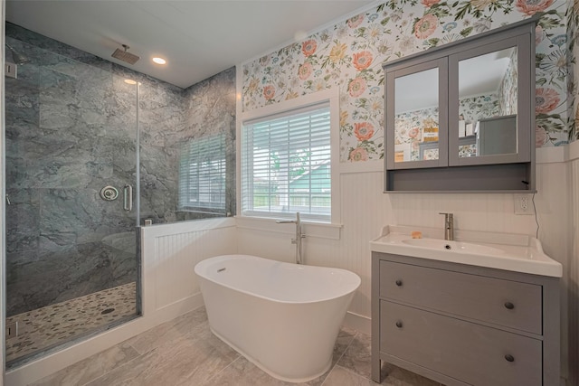 8302 Magna St, Houston, TX 77093 - bathroom featuring a marble finish shower, wainscoting, a soaking tub, vanity, and a decorative wall