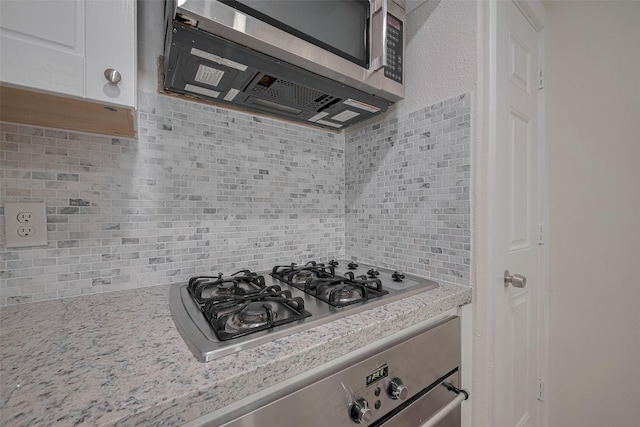 8302 Magna St, Houston, TX 77093 - kitchen with stainless steel appliances, backsplash, and light stone countertops
