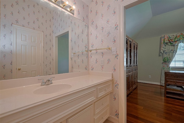 4707 Gladesdale Park Ln, Katy, TX 77450 - bathroom featuring wood finished floors, wallpapered walls, lofted ceiling, vanity, and baseboards