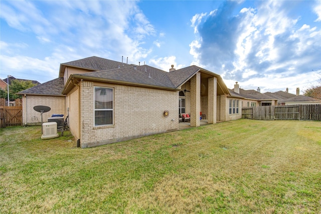 21714 Honeysuckle Grove Ln, Richmond, TX 77469 - rear view of house with a shingled roof, brick siding, and central AC unit