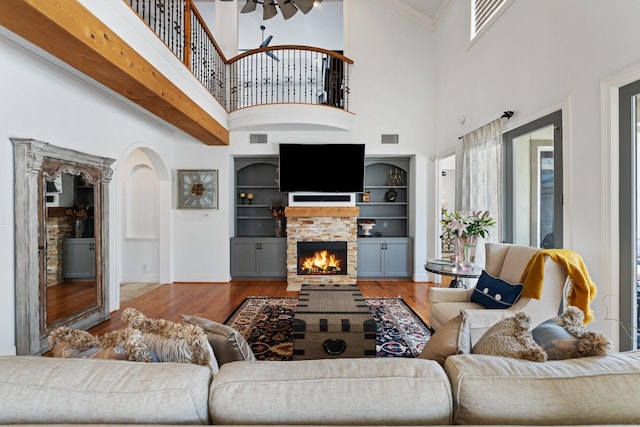 4021 Glenshire St, Houston, TX 77025 - living area featuring wood finished floors, a stone fireplace, a towering ceiling, arched walkways, and built in features