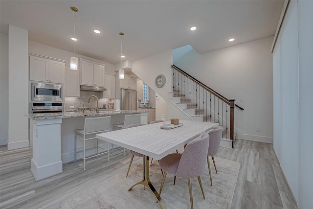 5038 Galahad Ct, Missouri City, TX 77459 - dining space with light wood-style flooring, stairway, baseboards, and recessed lighting