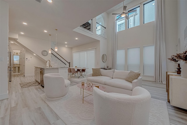 5038 Galahad Ct, Missouri City, TX 77459 - living room with ceiling fan, a towering ceiling, stairway, light wood-type flooring, and recessed lighting