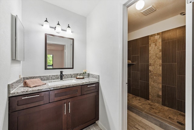 8020 Braesmain Dr Unit 1710, Houston, TX 77025 - full bath featuring vanity, a walk in shower, and wood finished floors