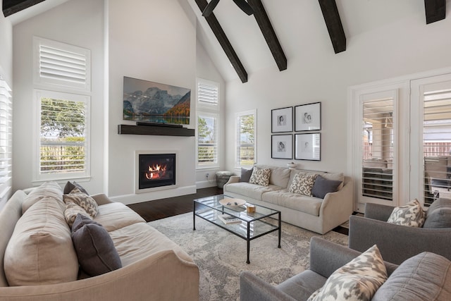 6914 Champion Trl, Katy, TX 77493 - living area with high vaulted ceiling, a glass covered fireplace, beamed ceiling, wood finished floors, and baseboards