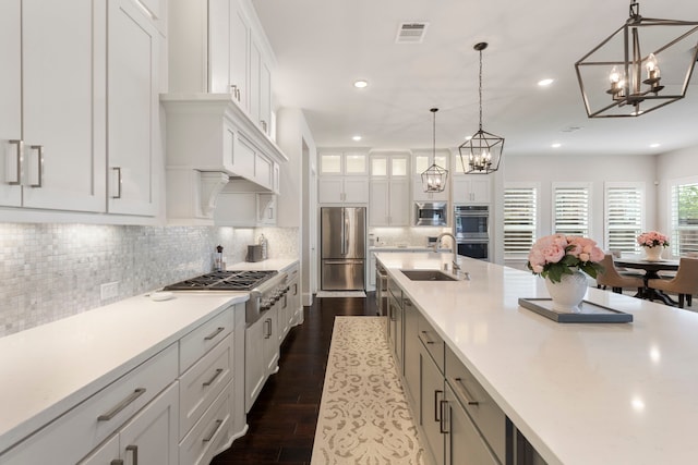 6914 Champion Trl, Katy, TX 77493 - kitchen with appliances with stainless steel finishes, a sink, a chandelier, dark wood finished floors, and recessed lighting